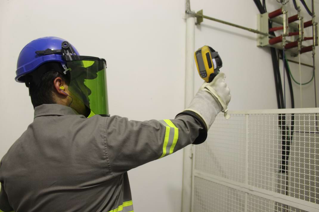 Técnico da Guima Conseco monitorando dados de manutenção em instalação industrial.