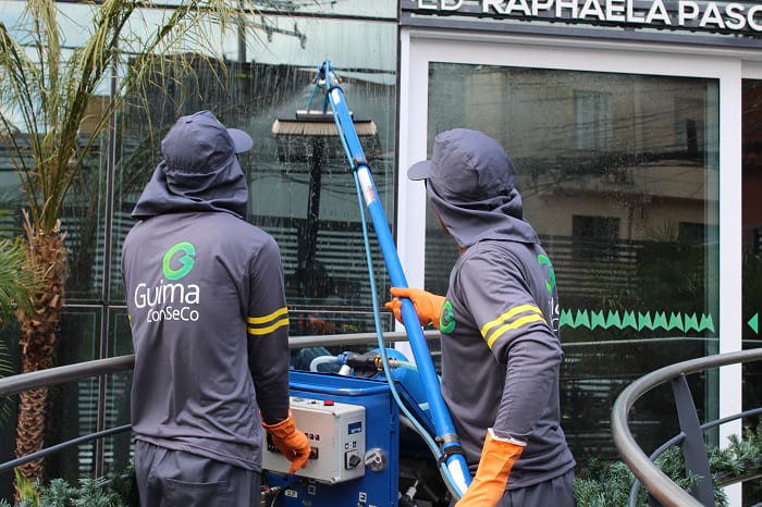 Imagem de profissionais da Guima Conseco realizando trabalho em altura de limpeza de vidros 